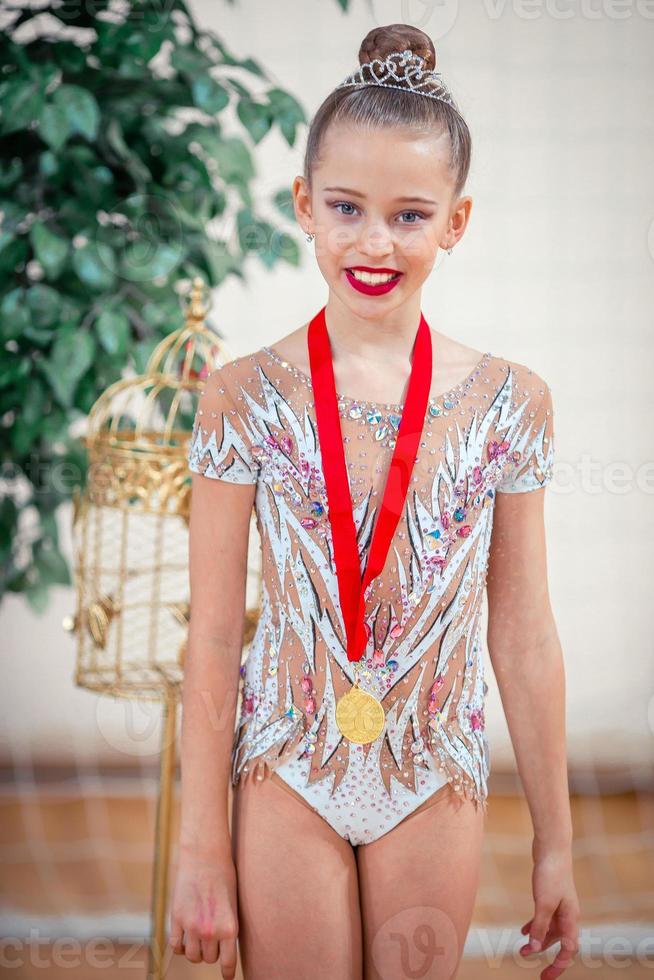 Beautiful little gymnast training on the carpet and ready for competitions photo