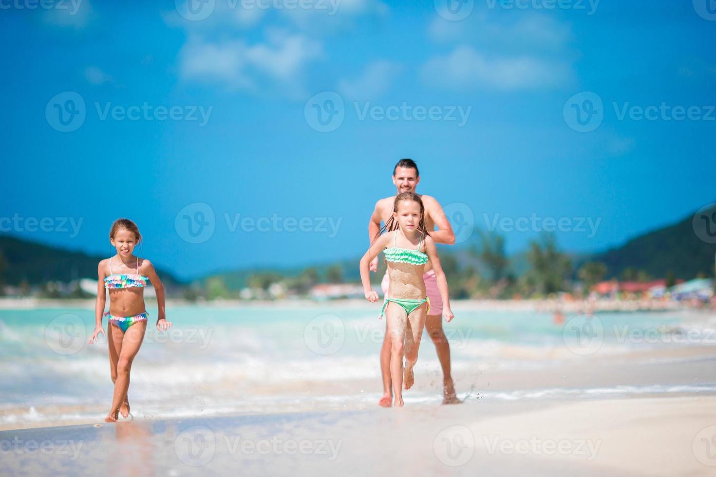 Father and little kids enjoying beach summer tropical vacation. Family playing on the beach photo