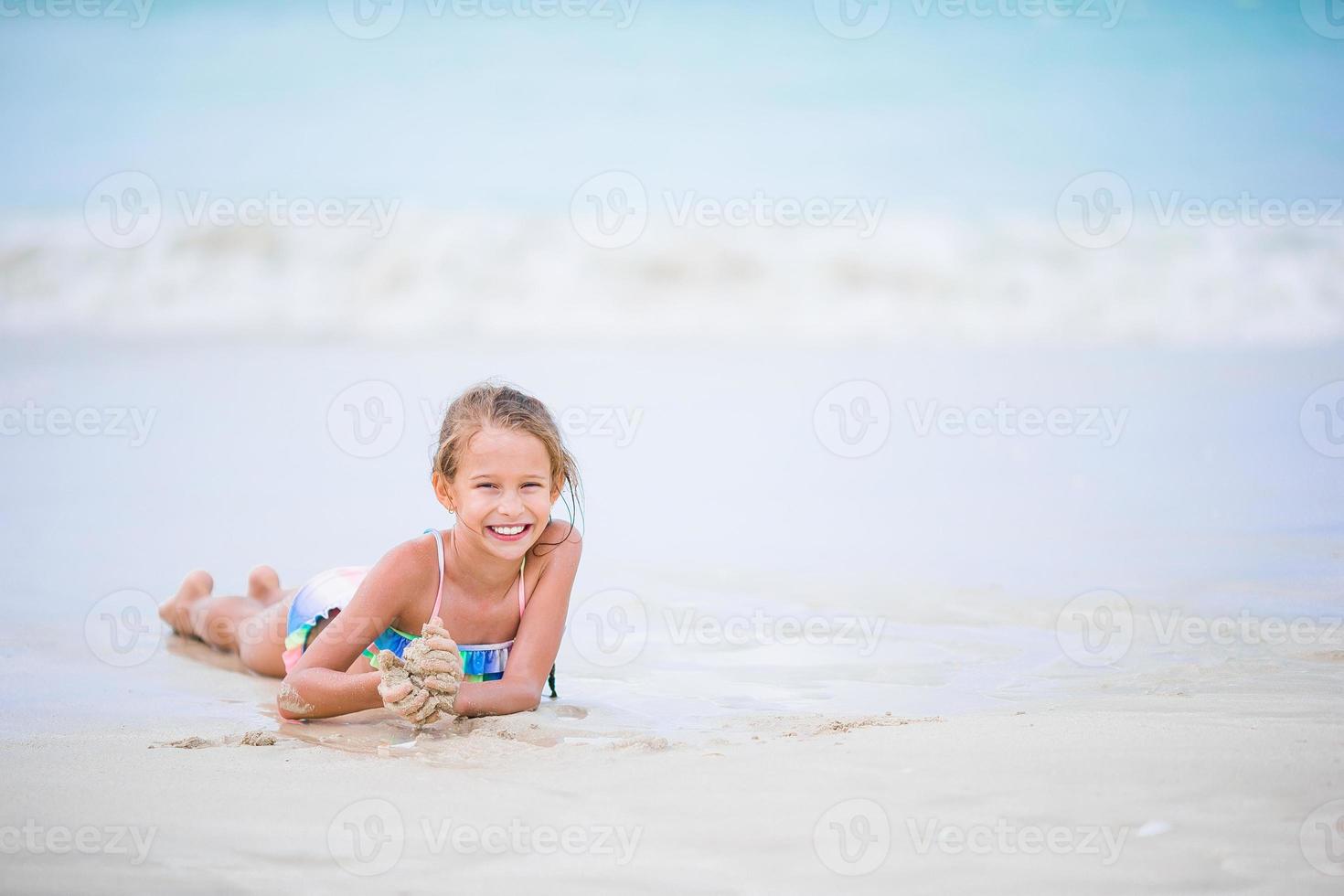 adorable niña en la playa durante las vacaciones de verano foto