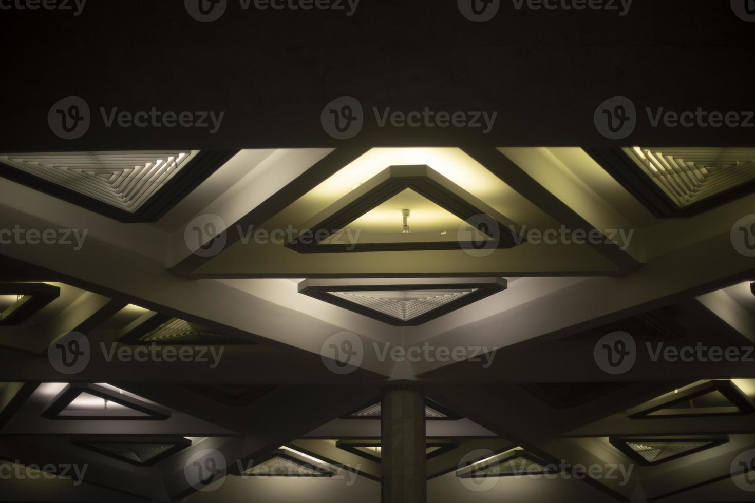 Light of lamps on ceiling. Architecture details. Triangles in building. photo