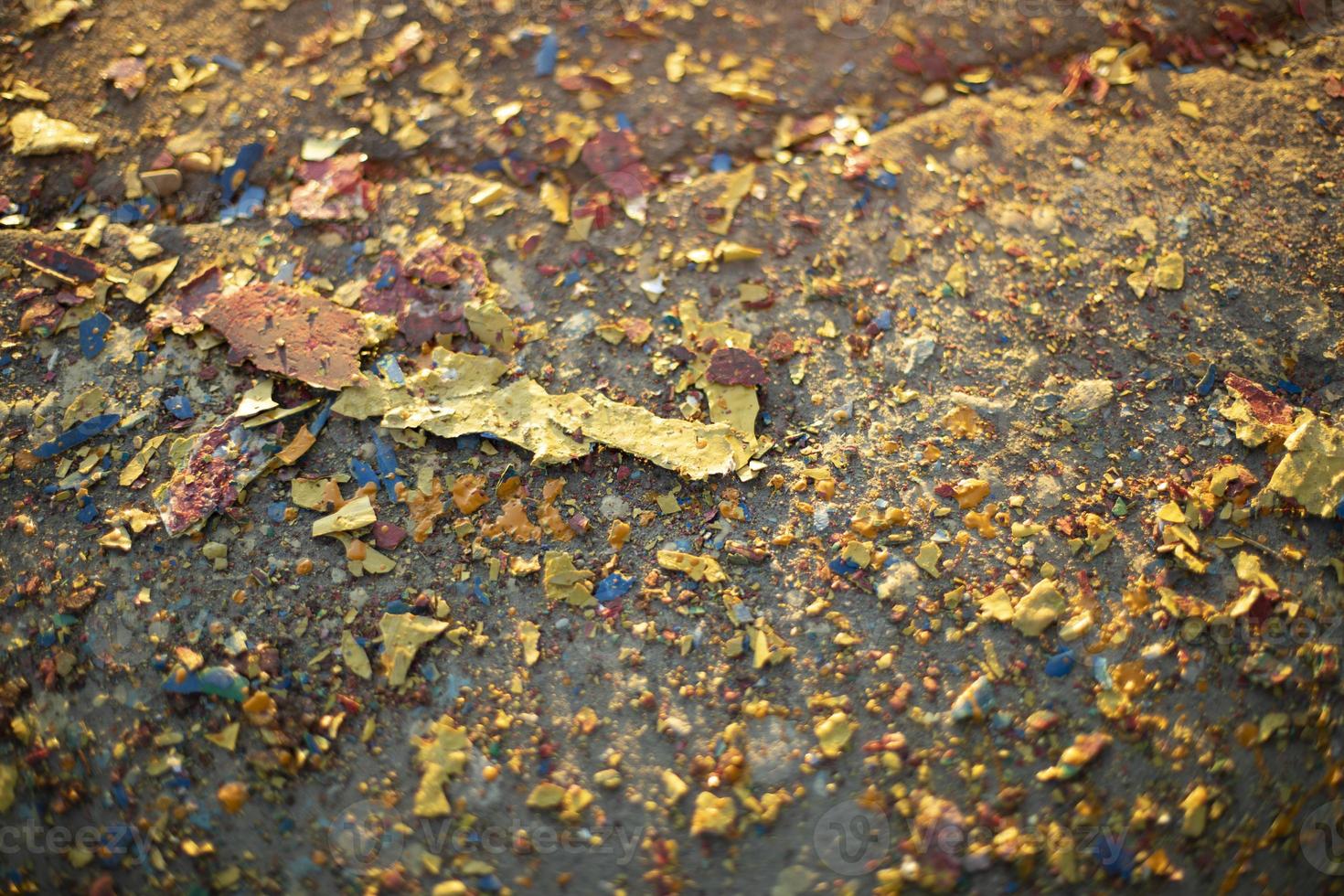 Pieces of paint lie on asphalt. Texture of colored dirt. photo