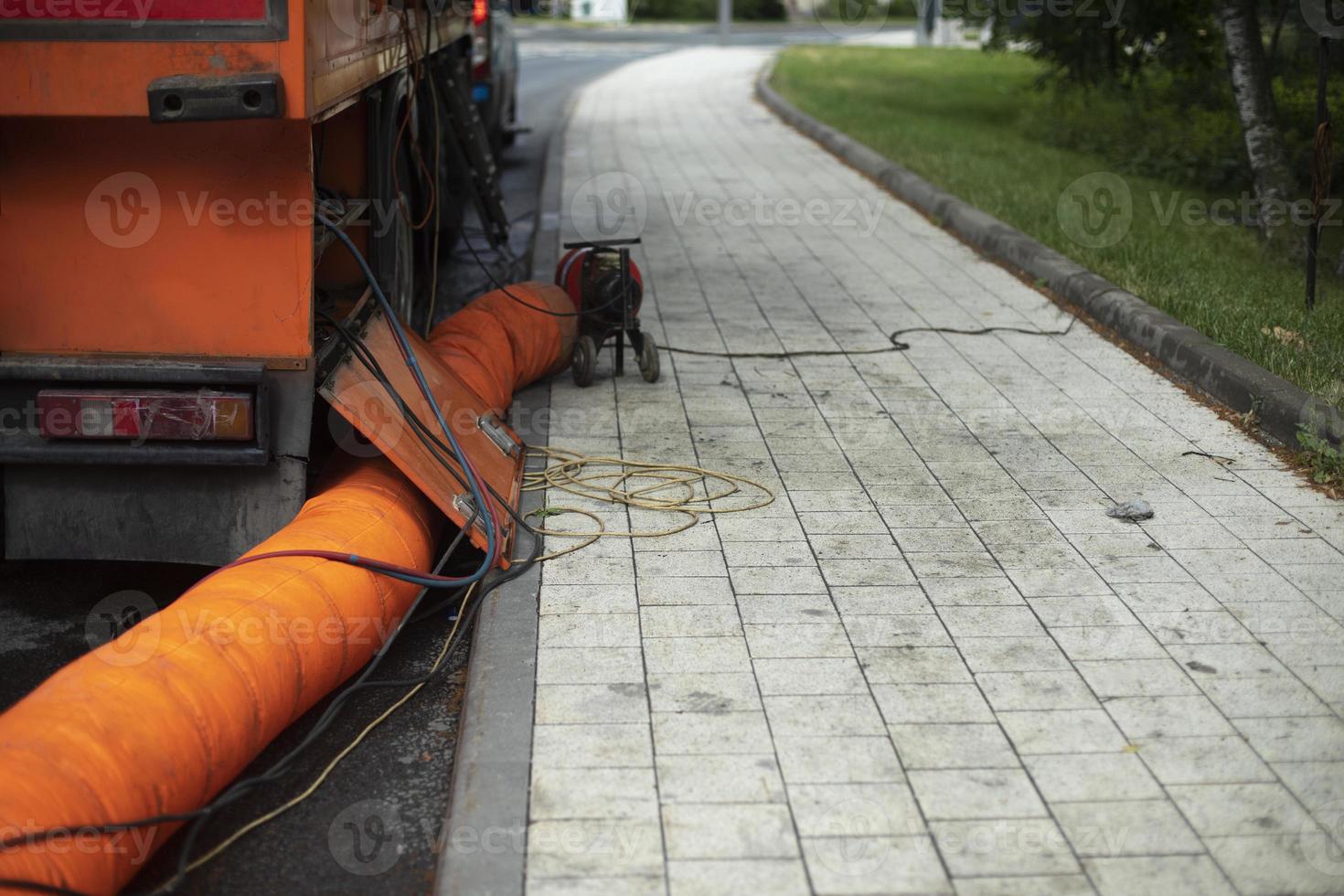 Sewer repair. Orange pipe. Details of works in city. photo