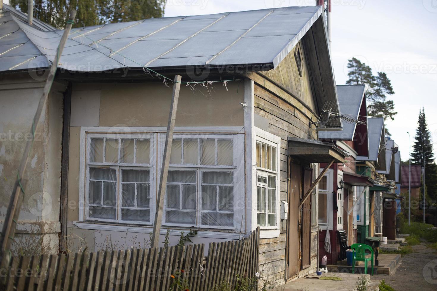 House in ghetto. Poor neighborhood in city. Hut made of planks. photo