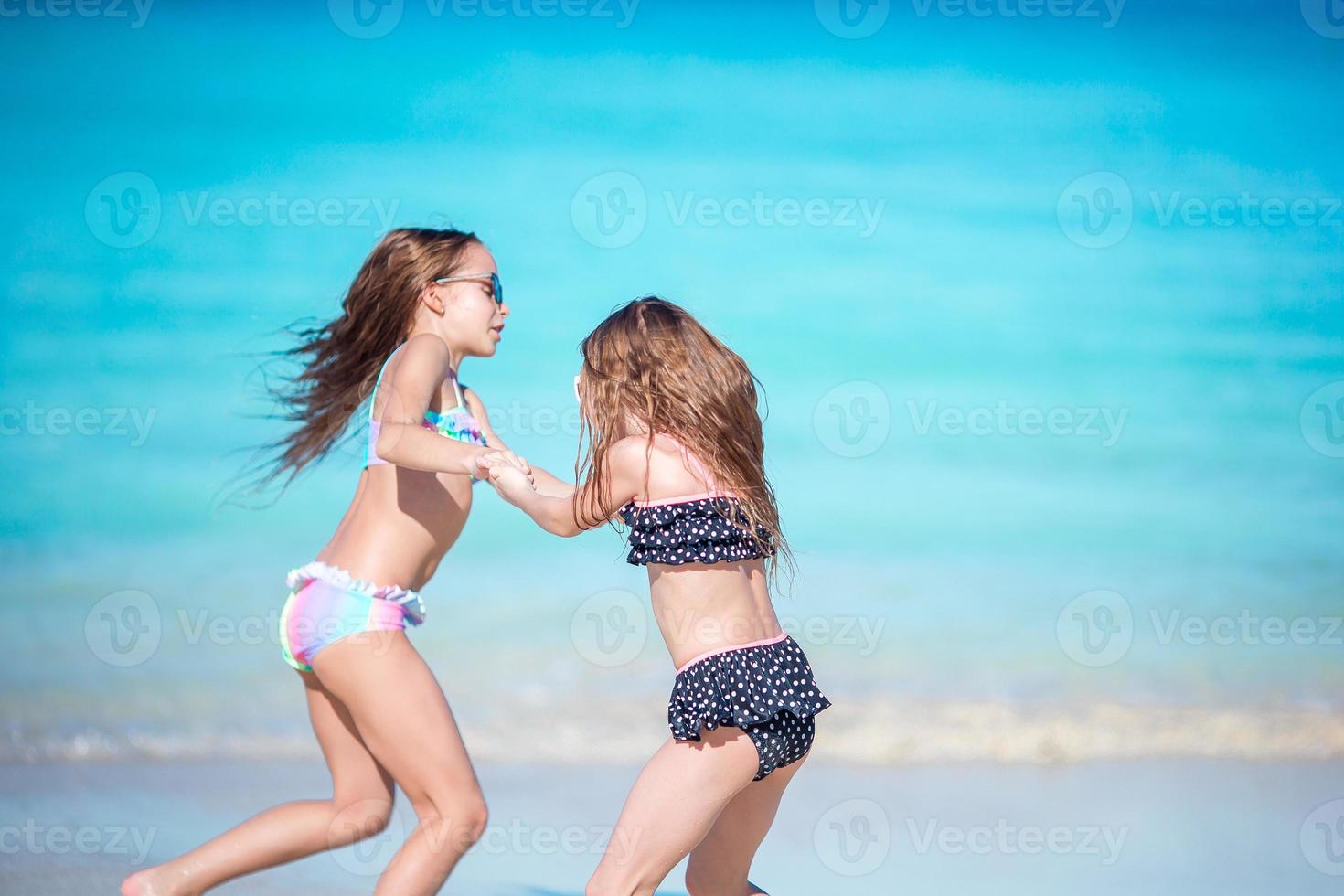 Little happy kids have a lot of fun at tropical beach playing together photo