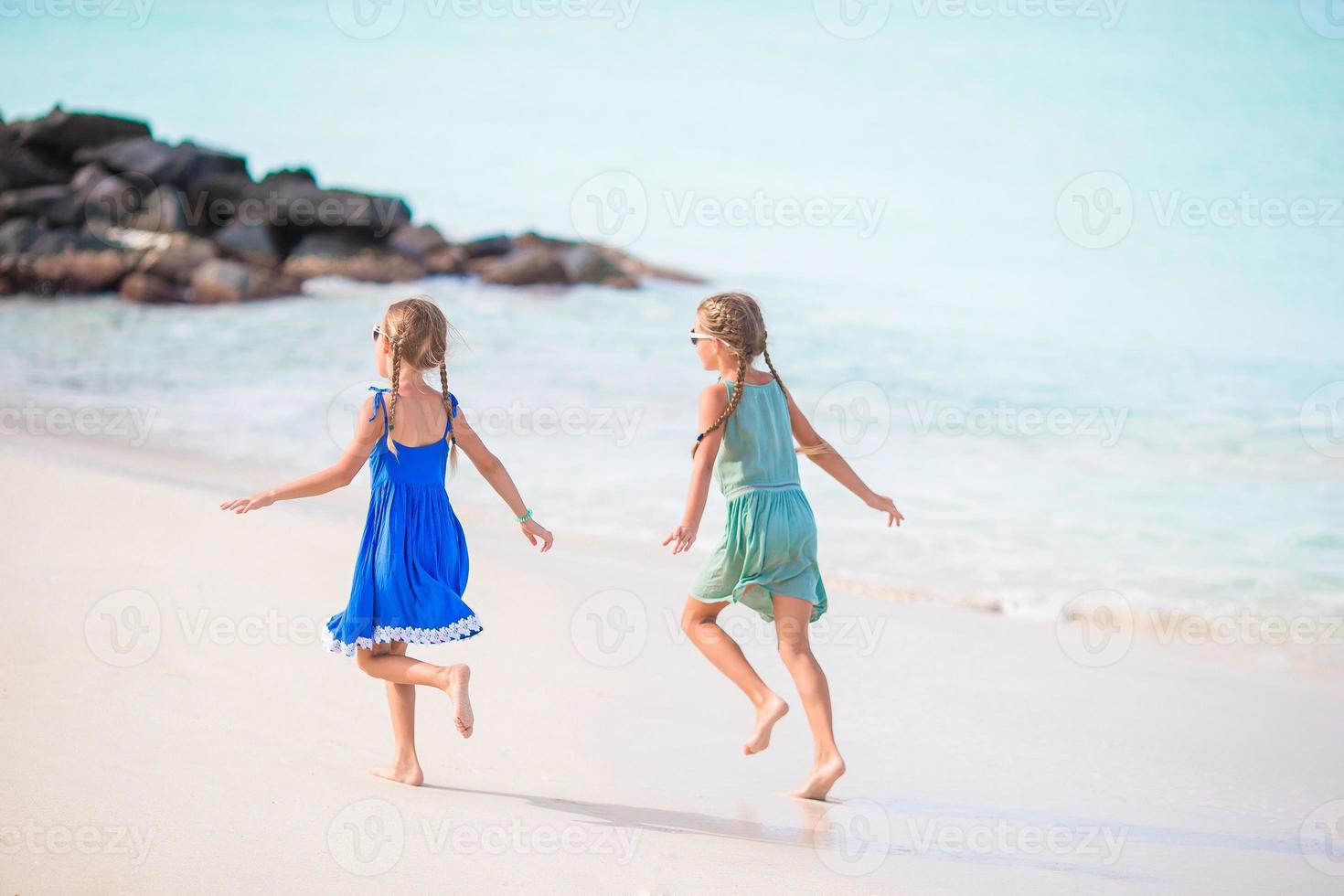 Little happy kids have a lot of fun at tropical beach playing together photo