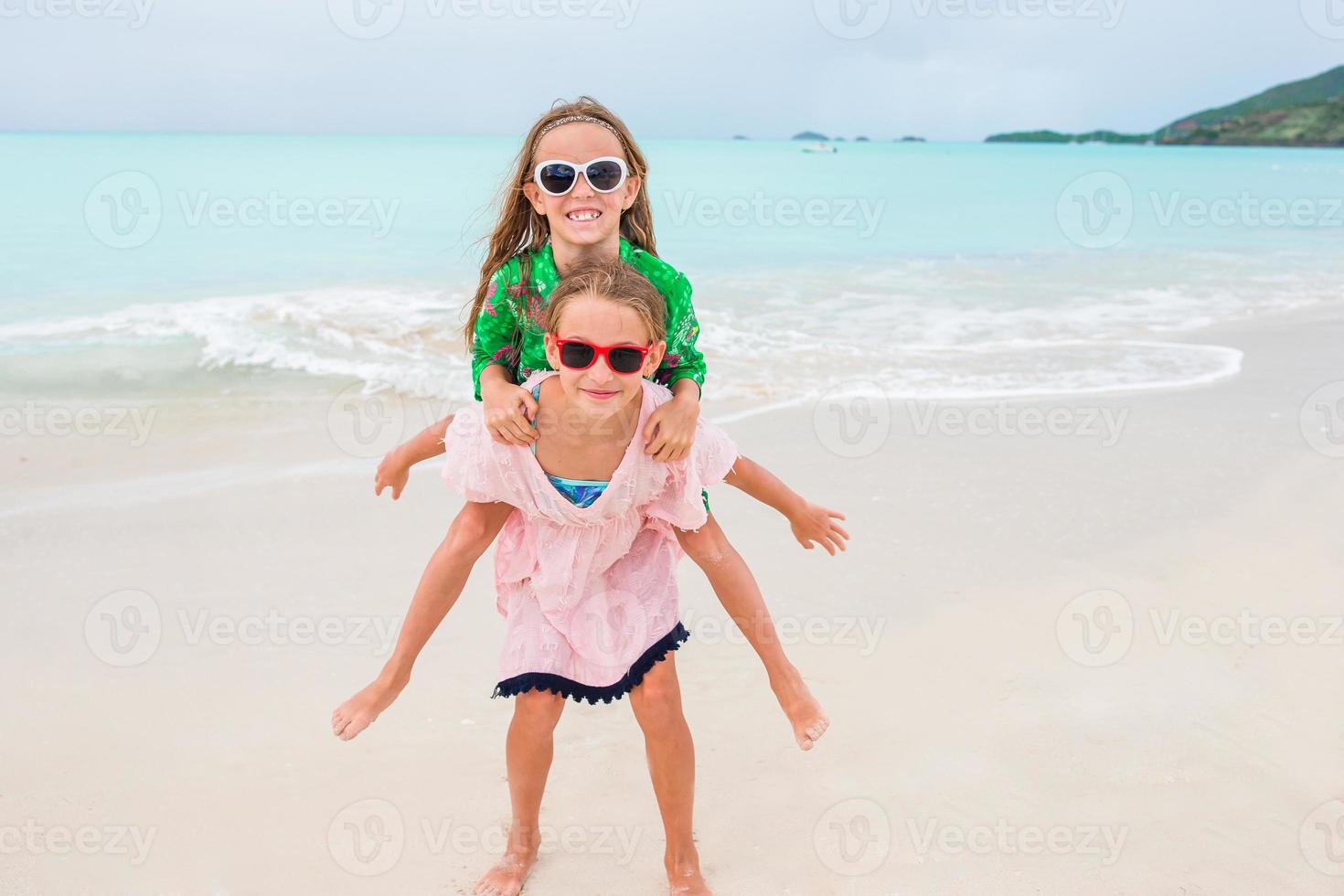 Adorable little girls walking on the beach photo
