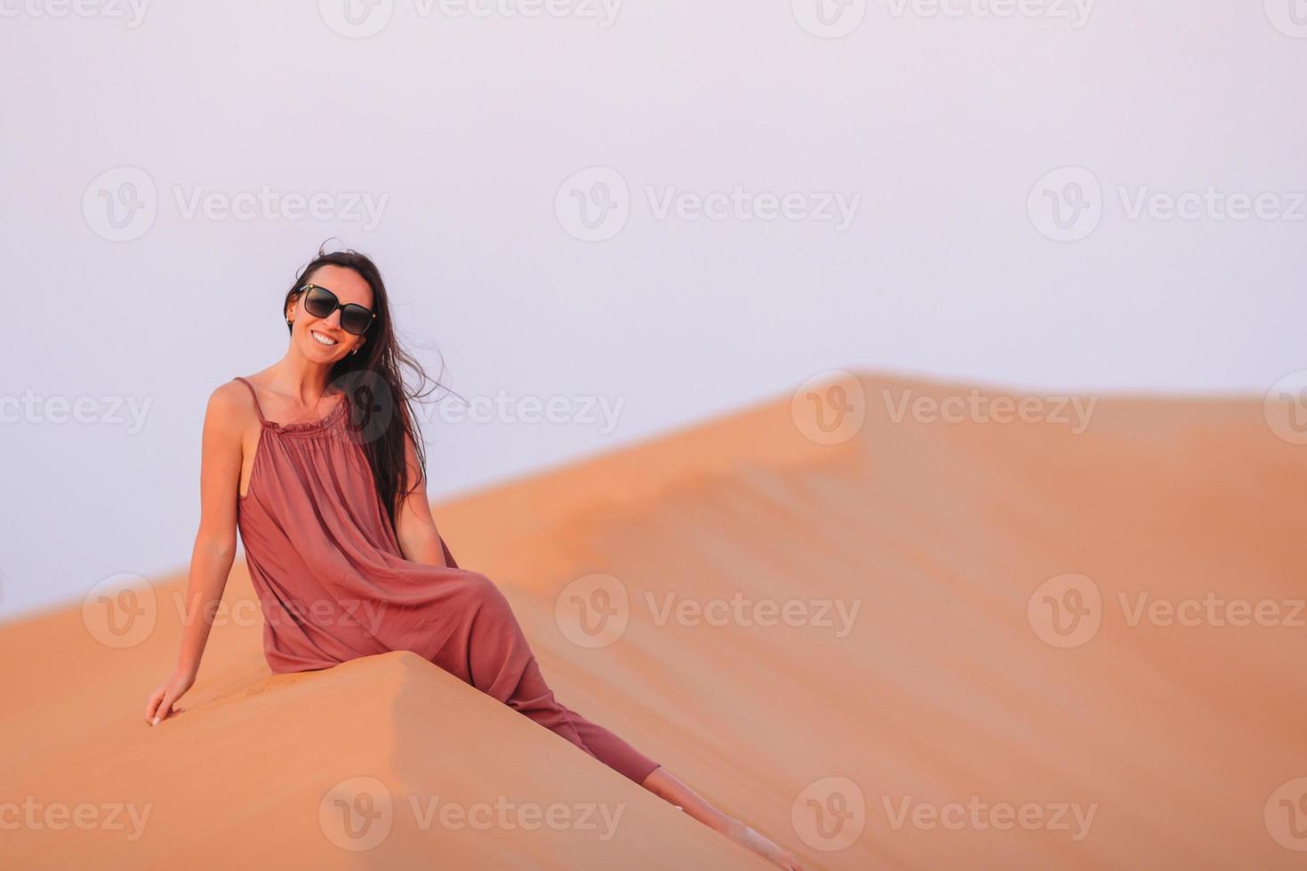 chica entre dunas en el desierto en emiratos árabes unidos foto