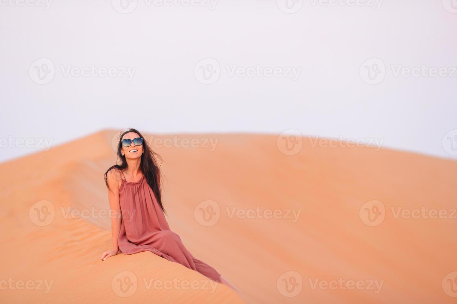 chica entre dunas en el desierto en emiratos árabes unidos foto