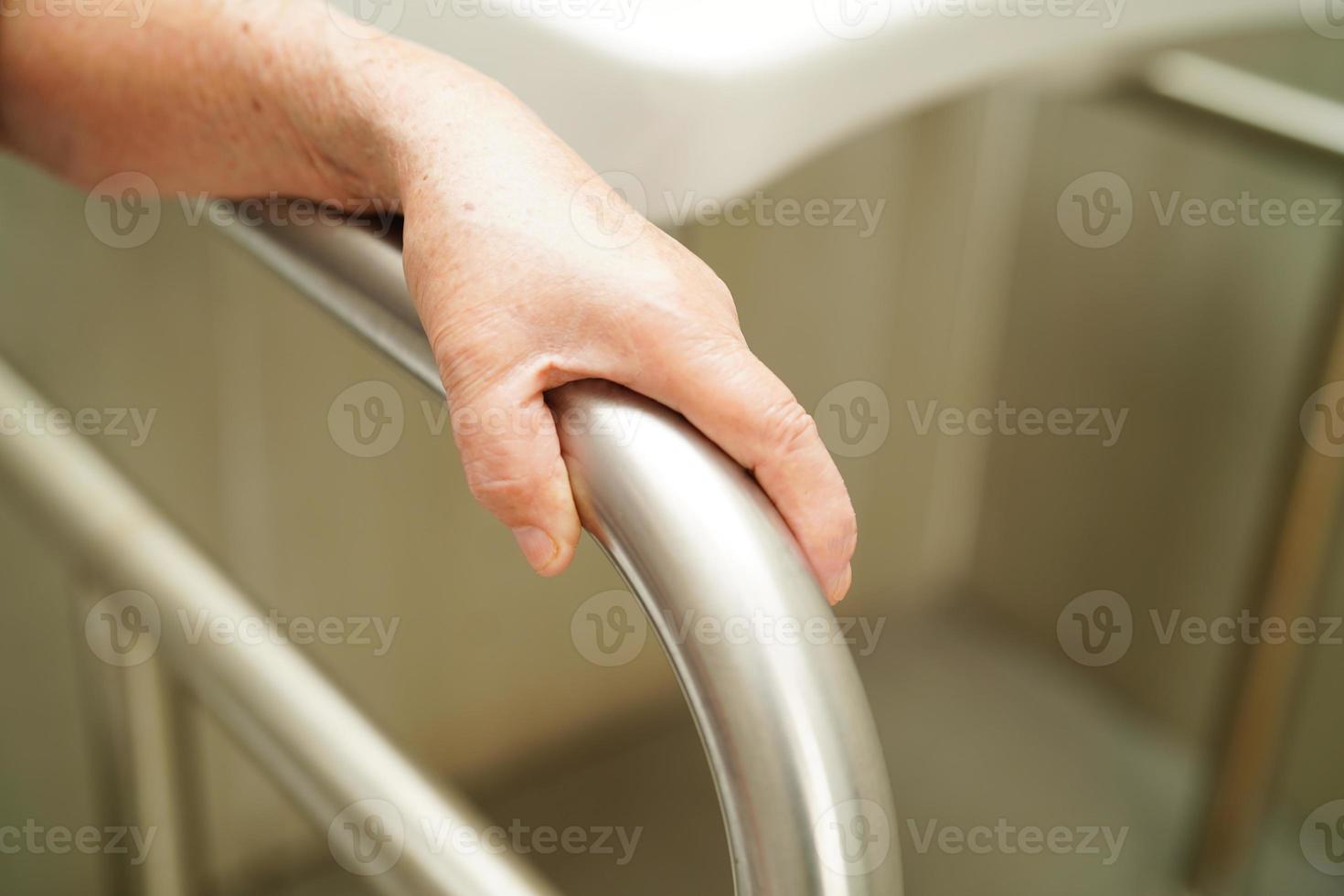 Asian elderly old woman patient use toilet support rail in bathroom, handrail safety grab bar, security in nursing hospital. photo