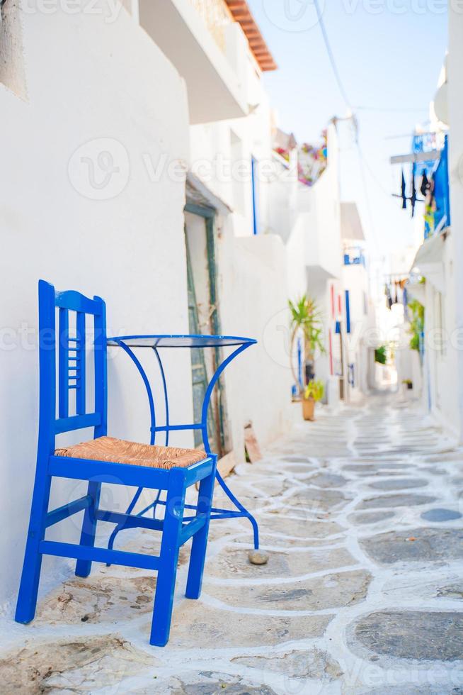 The narrow streets with blue balconies, stairs, white houses and flowers in beautiful village in Greece. photo