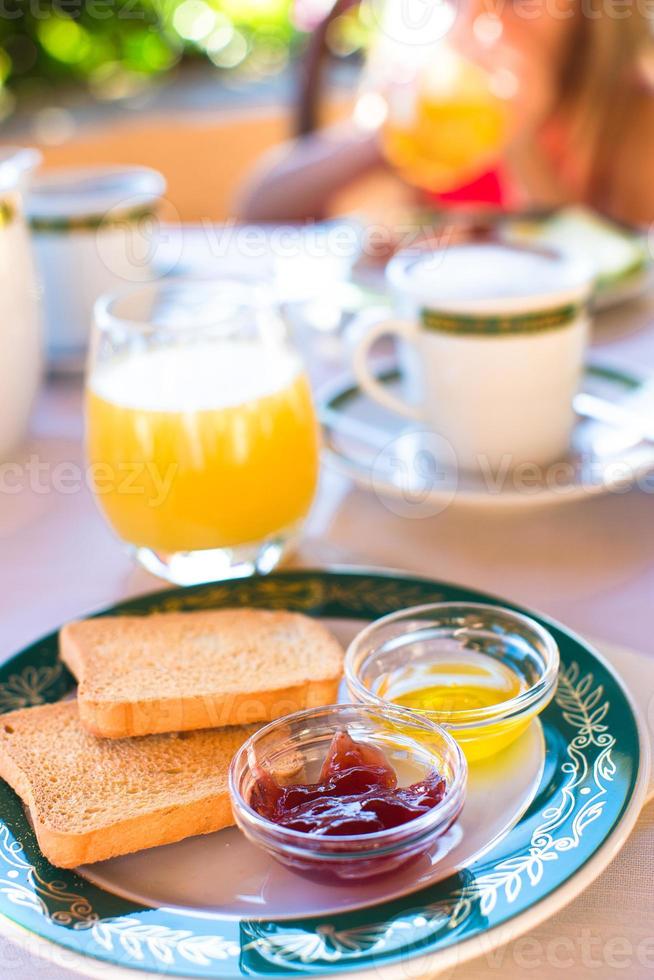 desayuno saludable con tostadas, mermelada y jugo en la mesa en el restaurante al aire libre foto