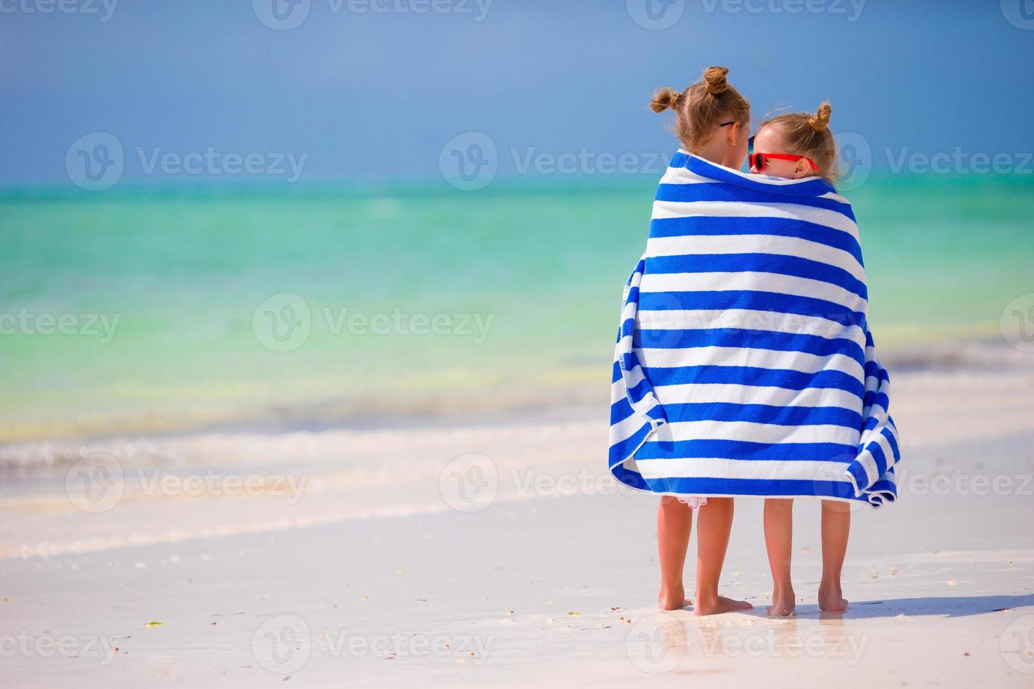 Girls wrapped in towel arter swimming at tropical beach photo