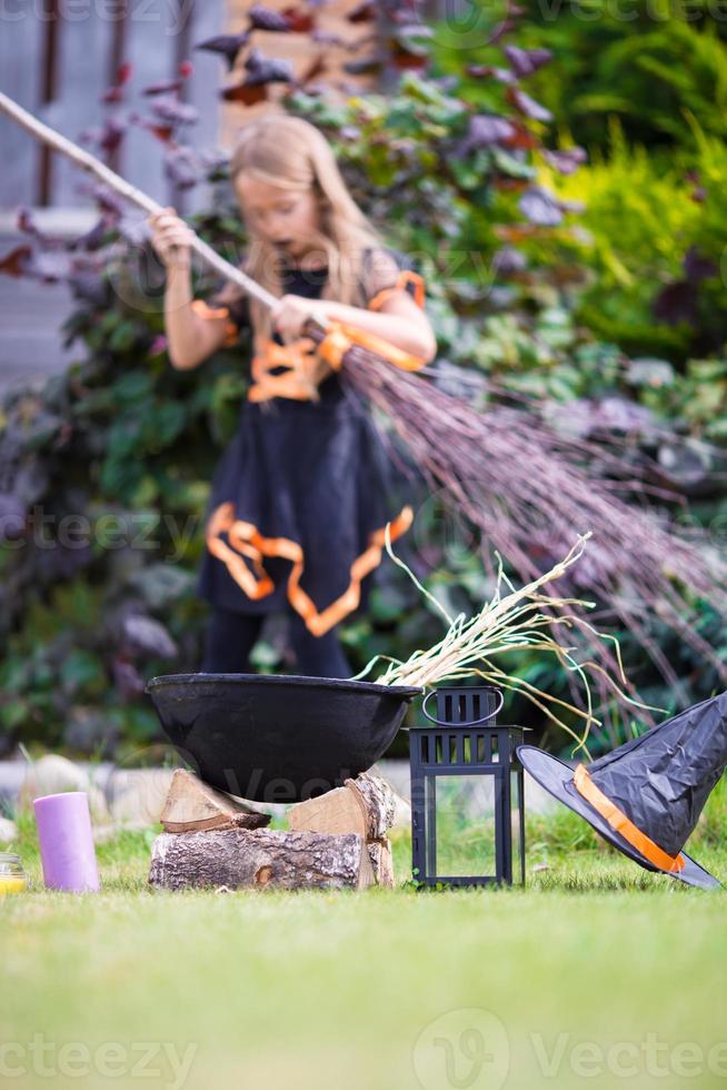 Happy little witch with broom on Halloween. Trick or treat. photo