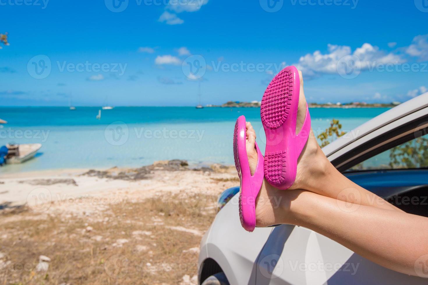 Flip Flops from the window of a car on background tropical beach photo