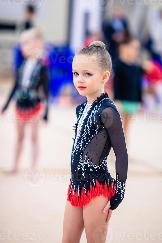 hermosa niña gimnasta activa con su actuación en la alfombra foto