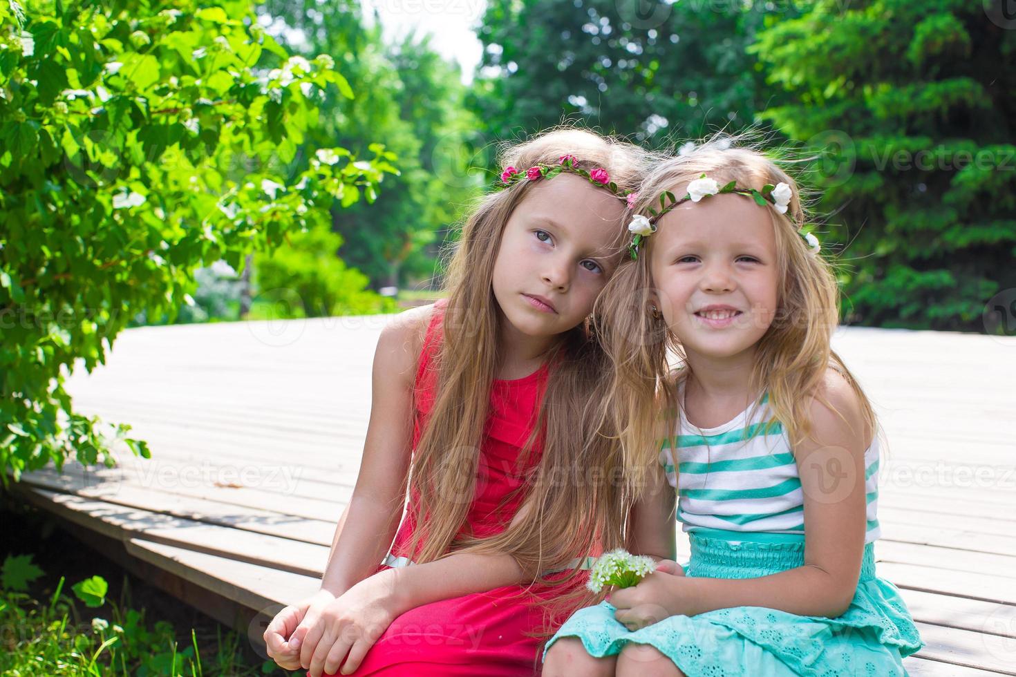 Happy adorable little girls enjoying warm summer day photo