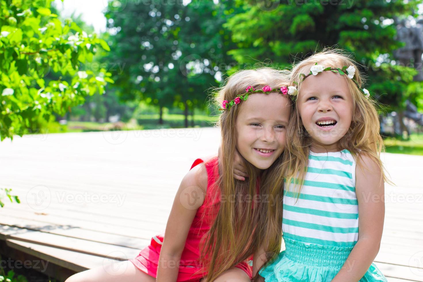 Happy adorable little girls enjoying warm summer day photo