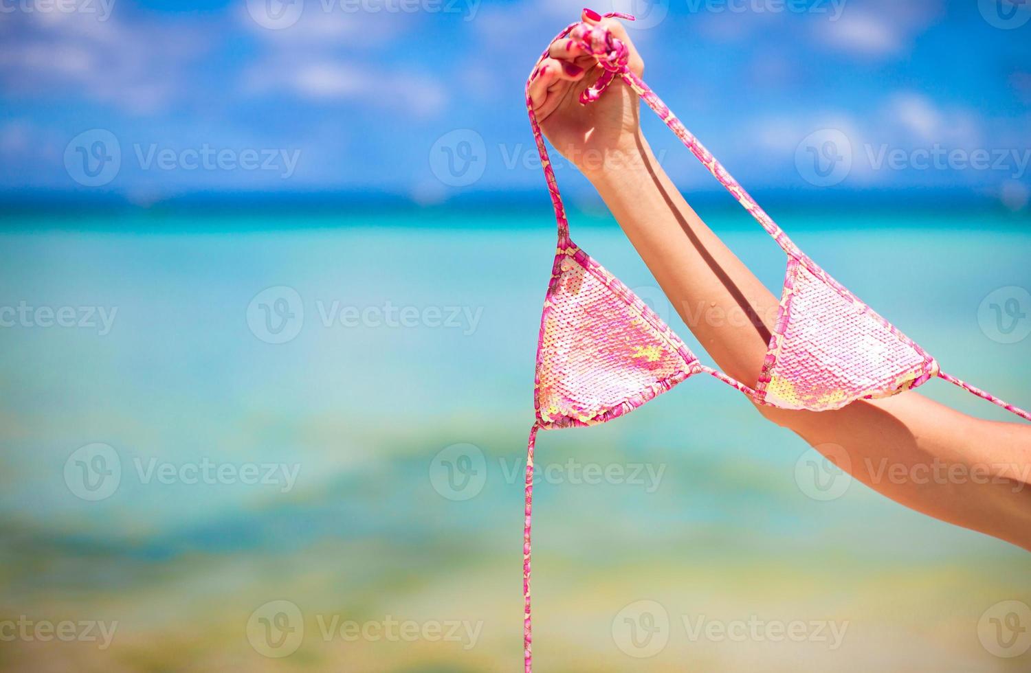 traje de baño rosa sobre fondo de mar tropical turquesa foto
