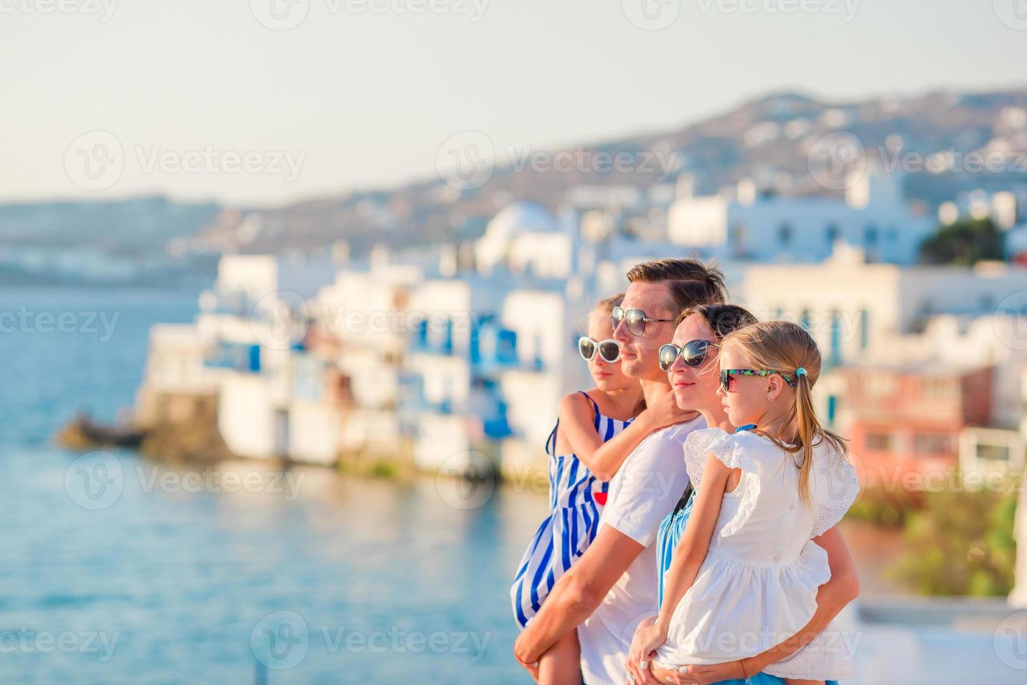 Family in Europe. Parents and kids on Little Venice background on Mykonos Island, in Greece photo