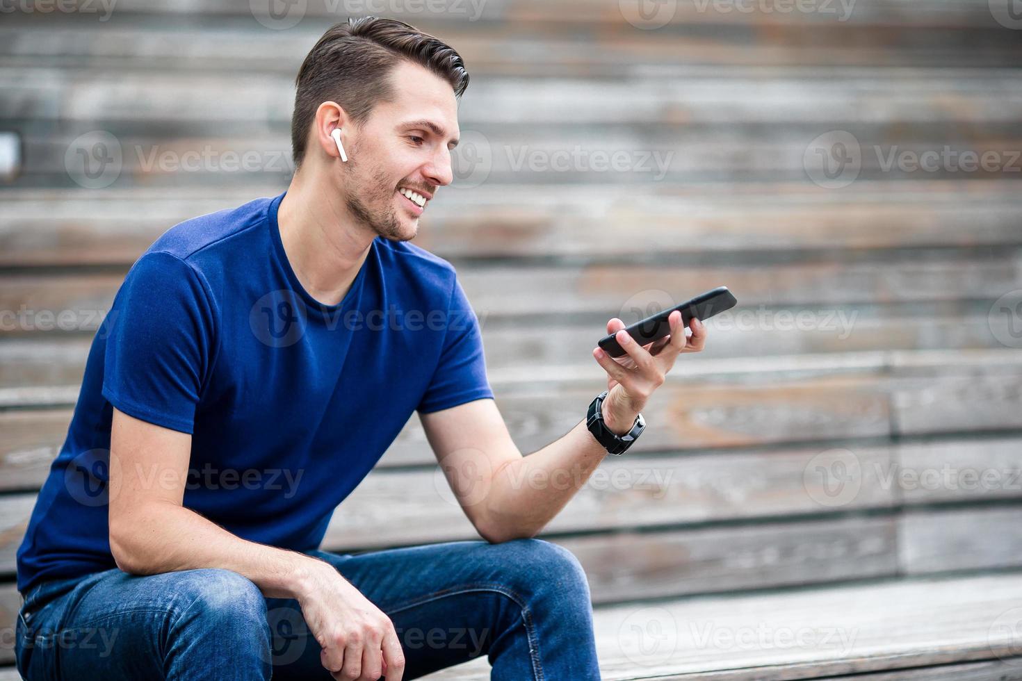 el hombre está leyendo un mensaje de texto en el teléfono móvil mientras camina en el parque foto