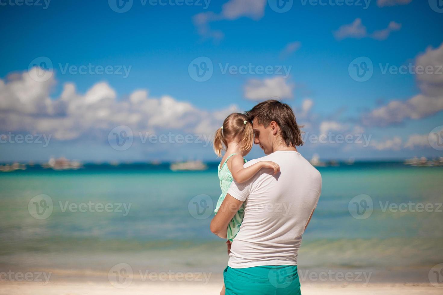 Portrait of a little girl hugging with dad on the beach photo