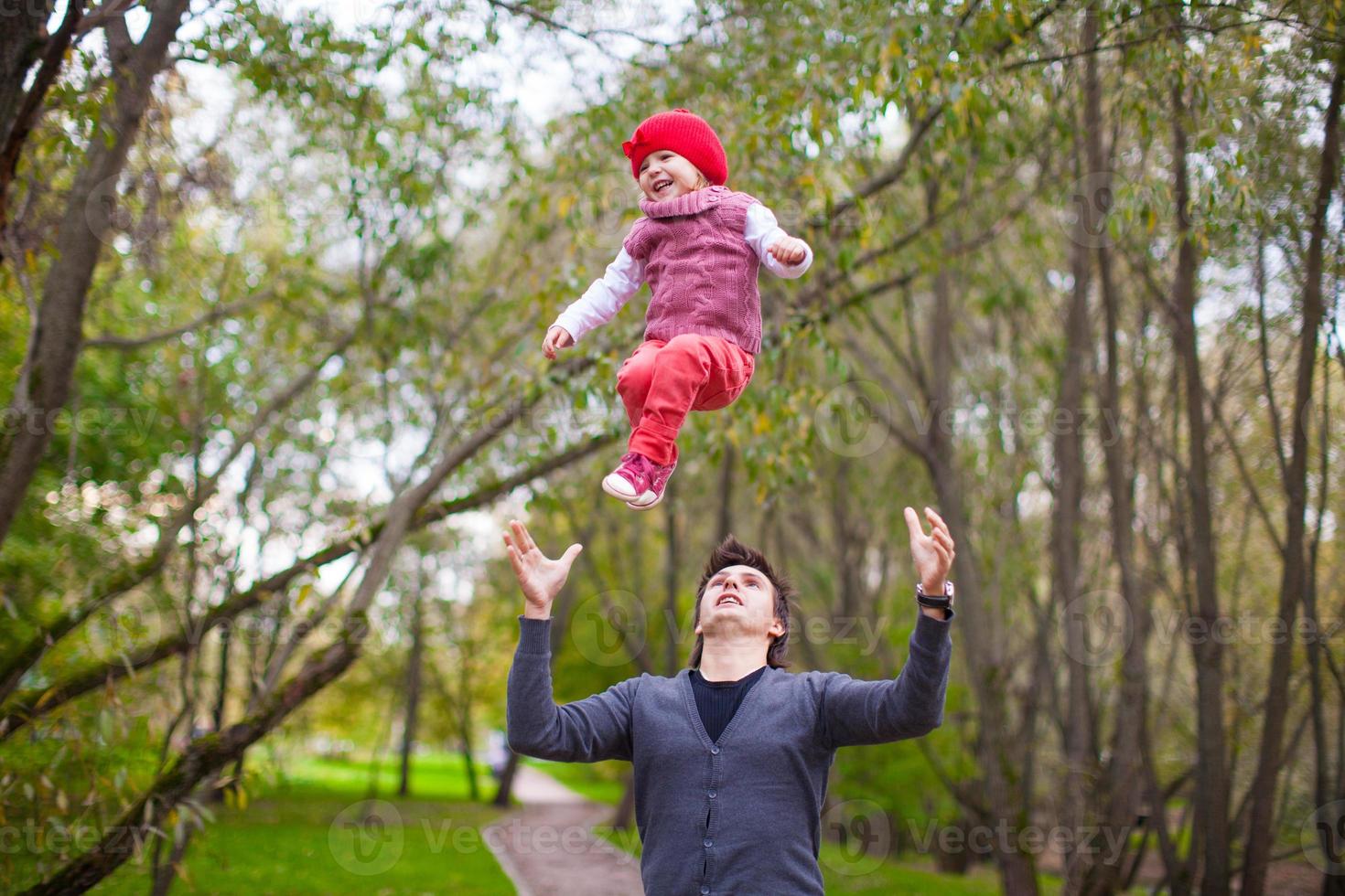 el joven padre con su linda hijita se divierte al aire libre foto