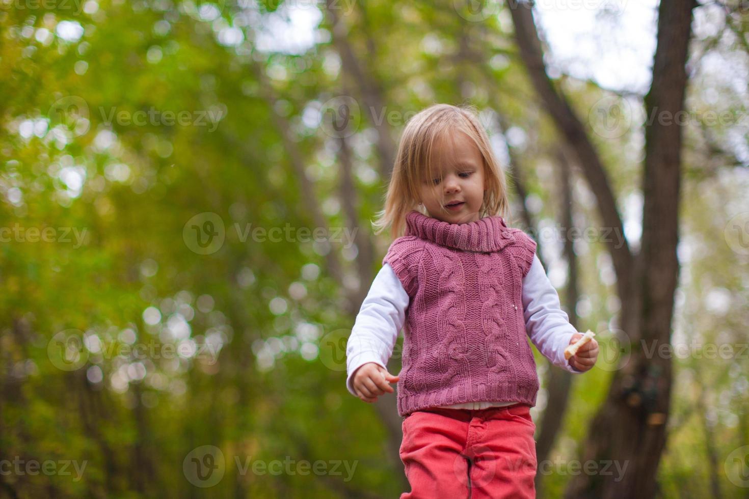 Little girl walking outdoor, having fun and laughing in autumn time photo