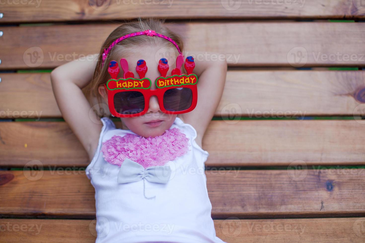 Cute little girl in red Happy Birthday glasses photo