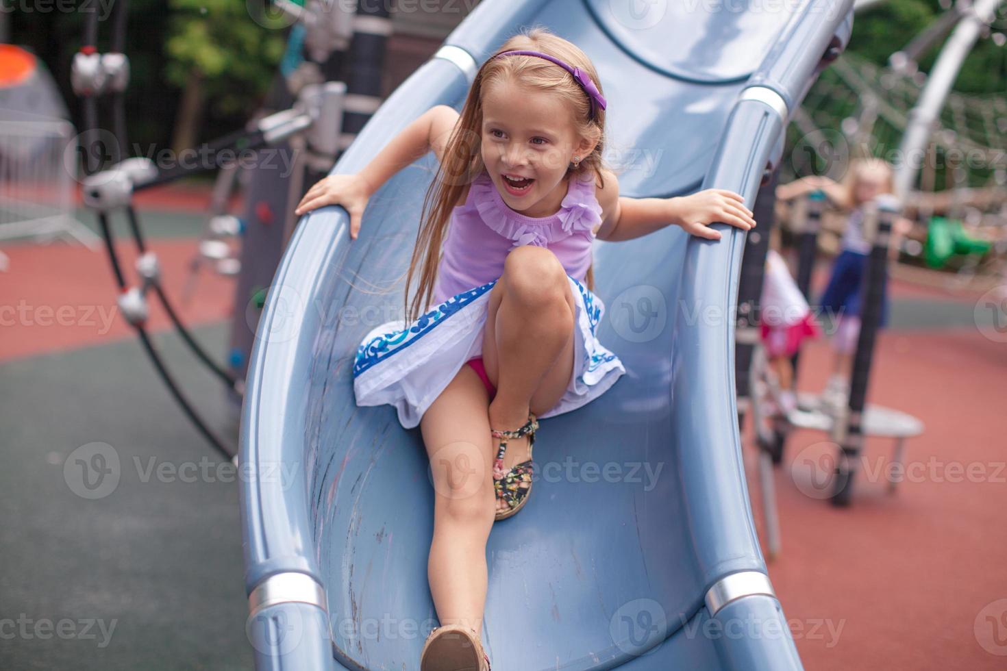 niña monta en la colina en un parque de atracciones foto