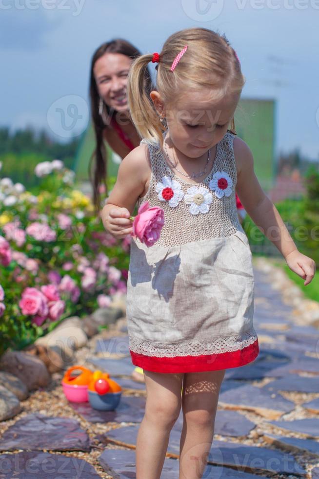 Young mother with her cute daughter have fun in the garden summer time photo