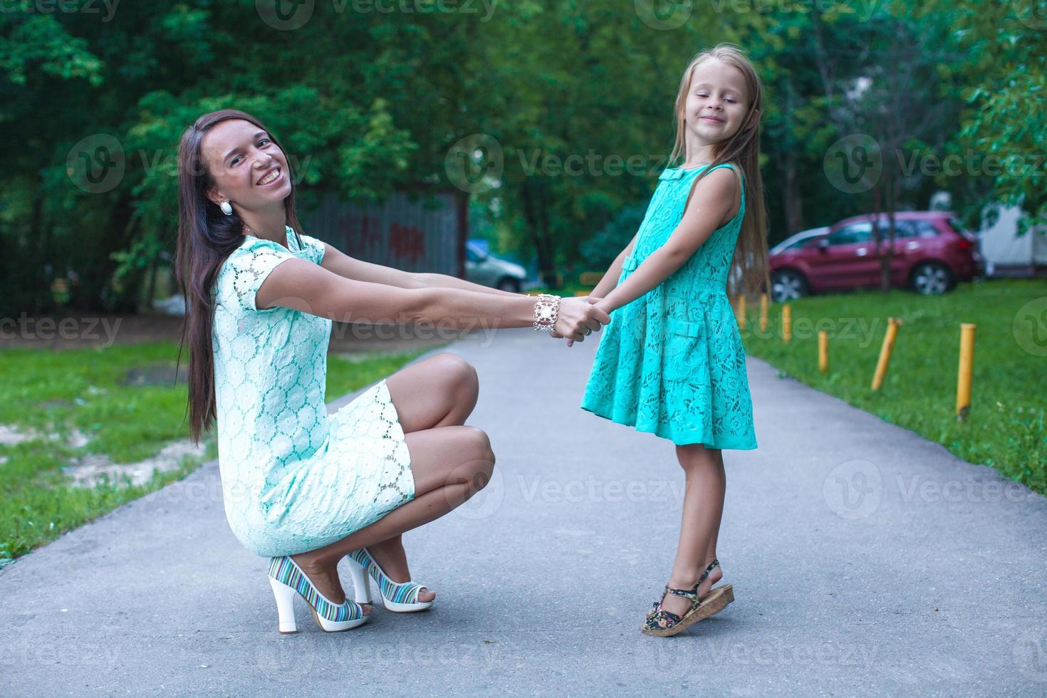 feliz joven madre y su hija divirtiéndose al aire libre foto