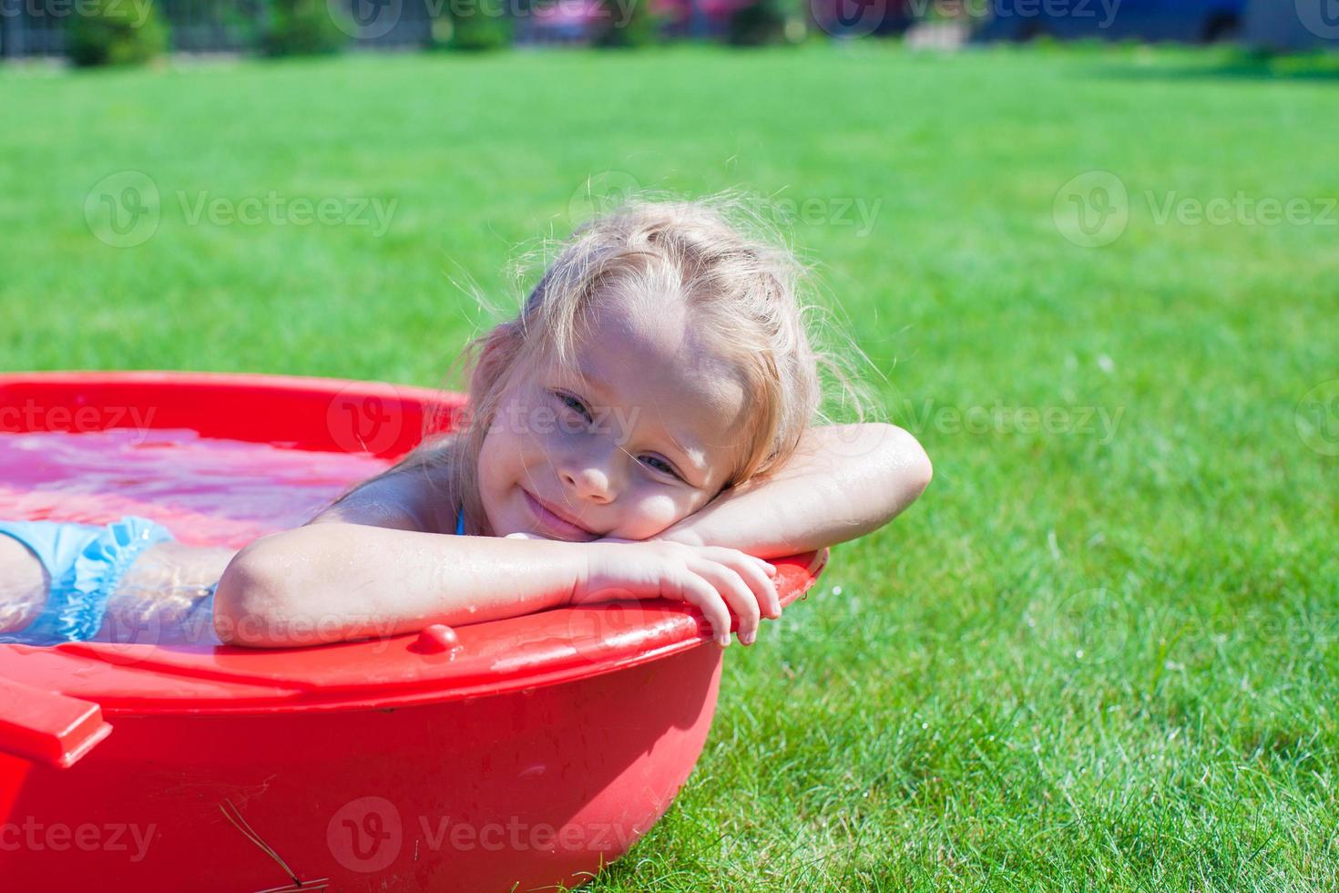 retrato encantador niña disfrutando de sus vacaciones en la piscina al aire libre foto