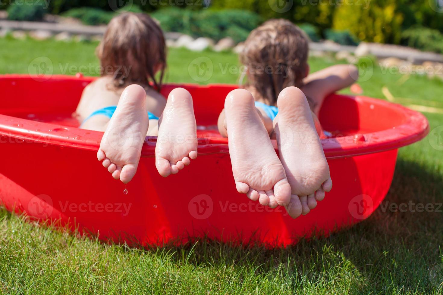 Close-up of feet two sisters in small pool photo