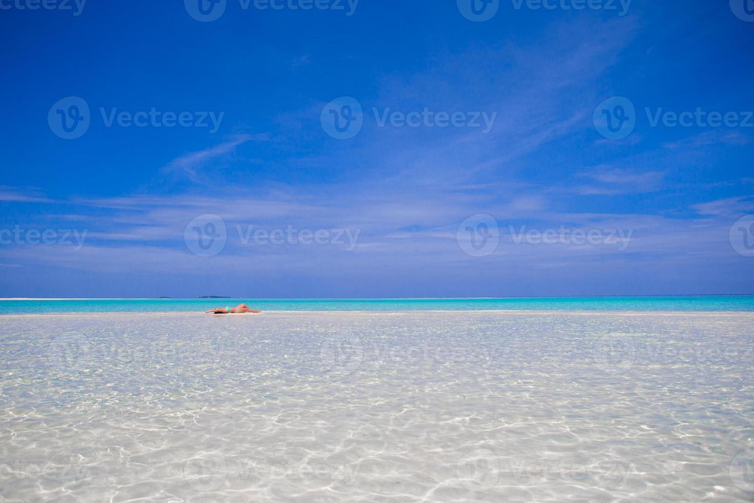 Young happy woman enjoy tropical vacation on white sandy beach photo