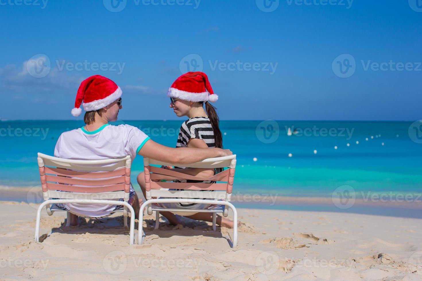 Young couple in Santa hats during beach vacation photo