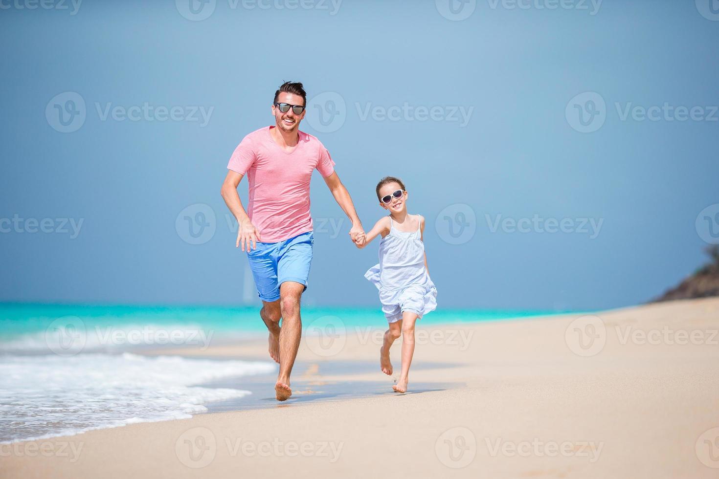 Family of father and sporty little girl having fun on the beach photo