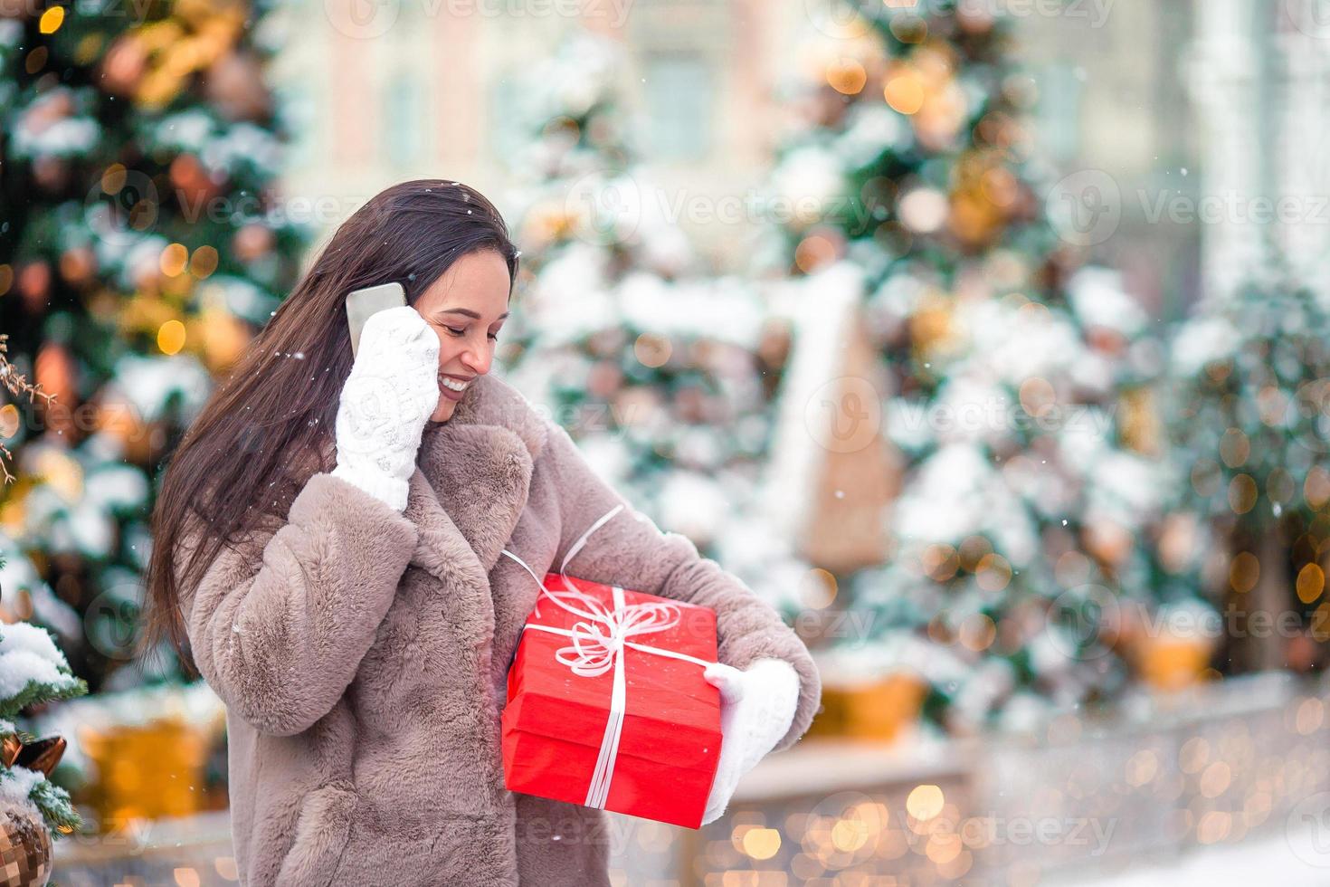 Happy girl near fir-tree branch in snow for new year. photo