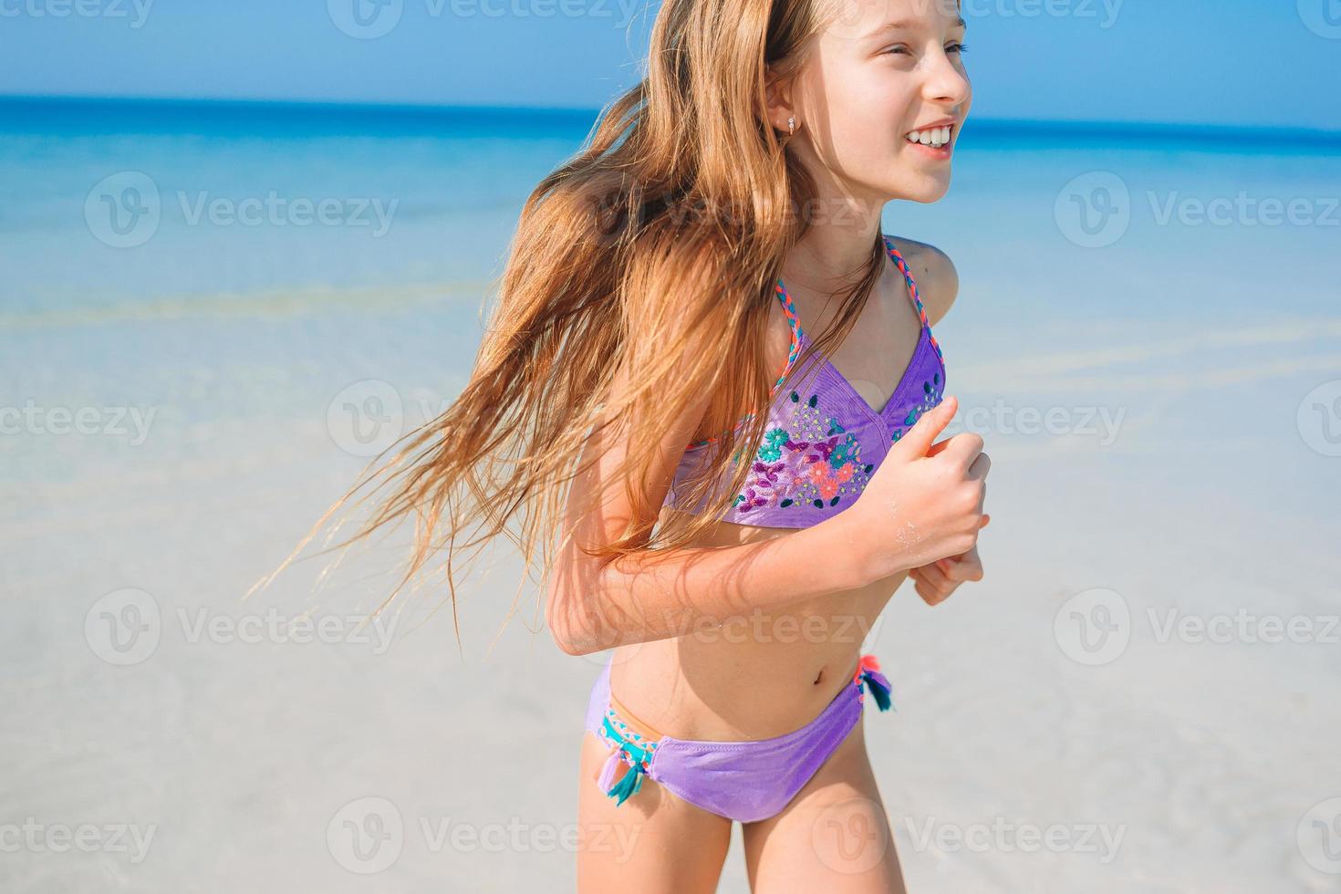 Adorable little girl have fun at tropical beach during vacation photo
