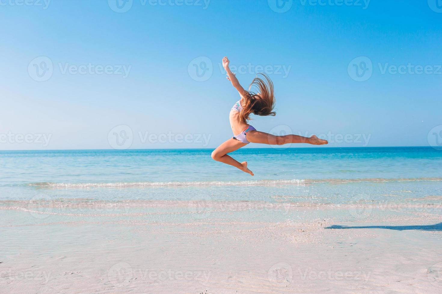 Adorable little girl have fun at tropical beach during vacation photo