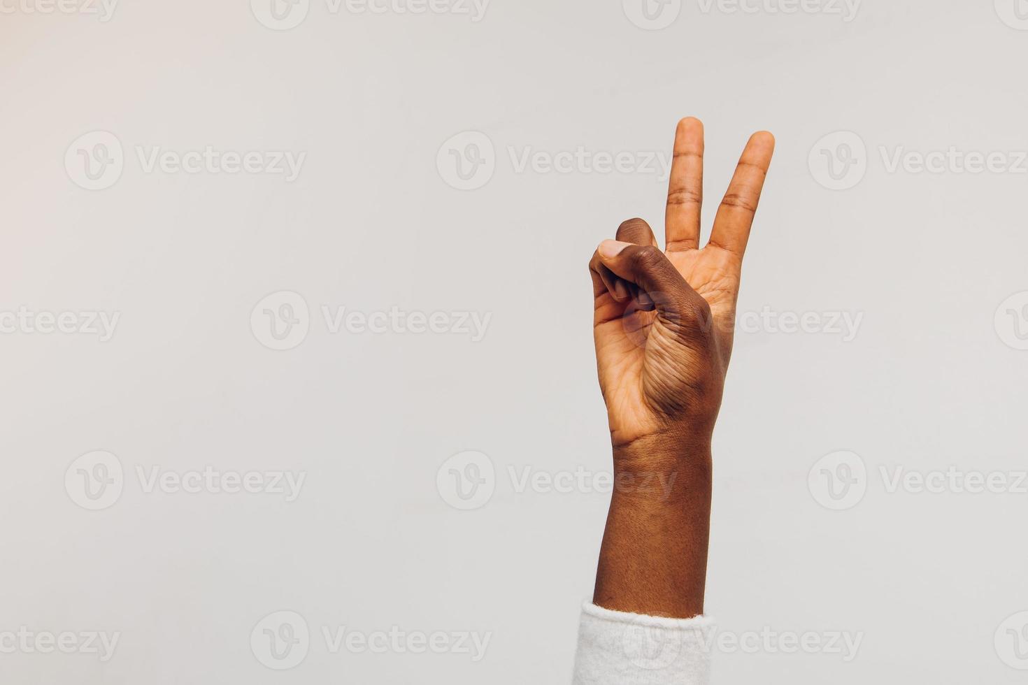 una mano aislada en blanco haciendo el signo de la victoria foto