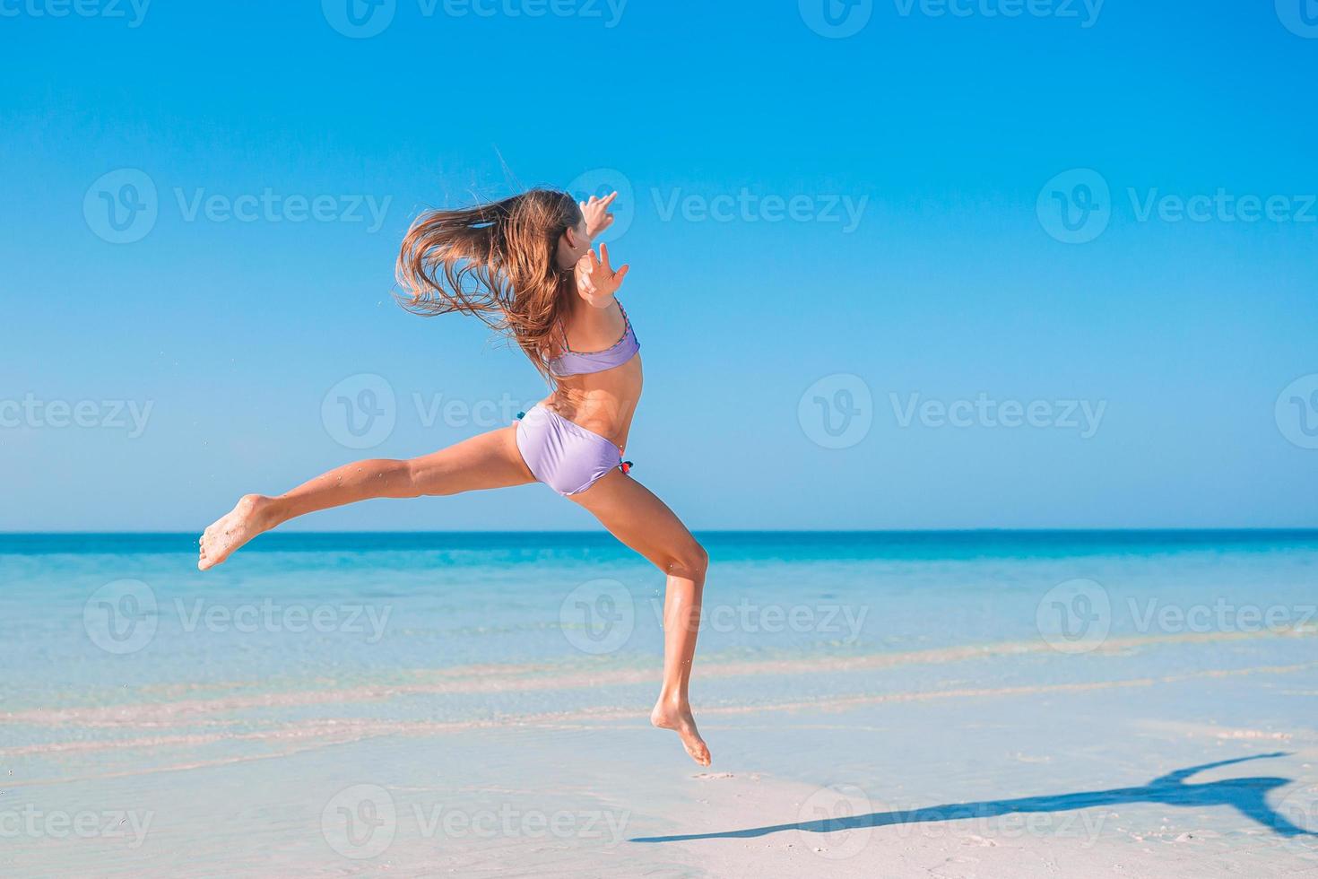 Active little girl at beach having a lot of fun. photo