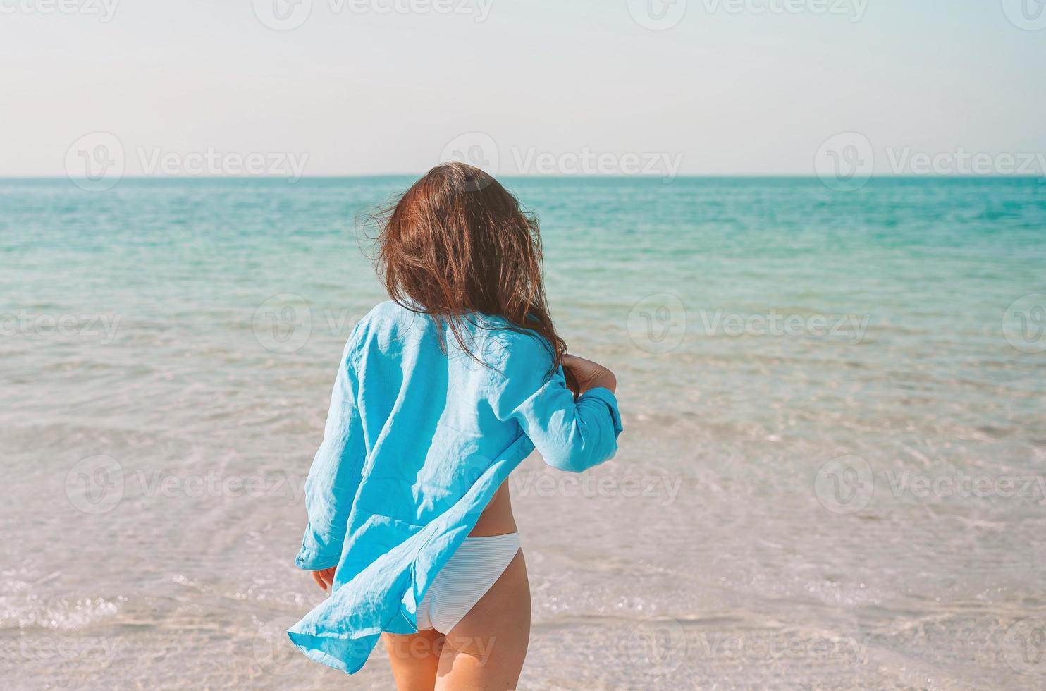 Woman laying on the beach enjoying summer holidays looking at the sea photo