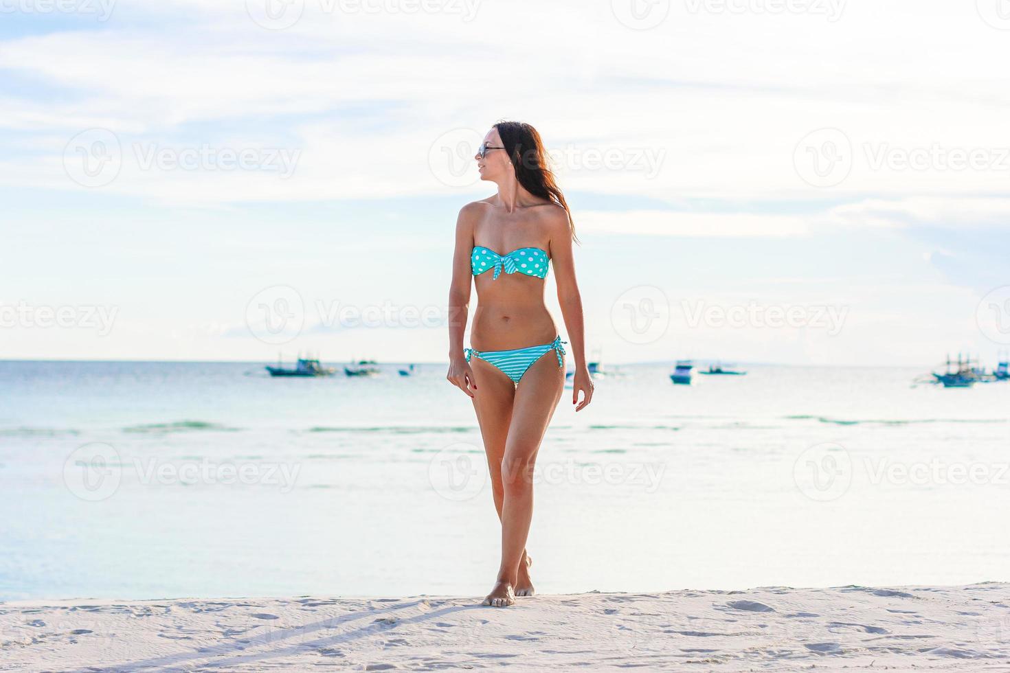 Woman laying on the beach enjoying summer holidays looking at the sea photo