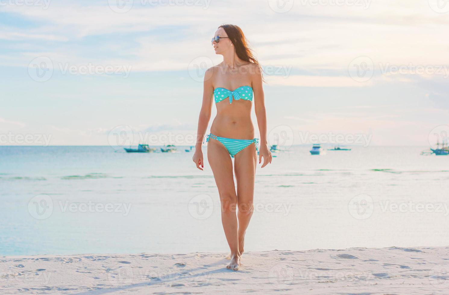 Woman laying on the beach enjoying summer holidays looking at the sea photo