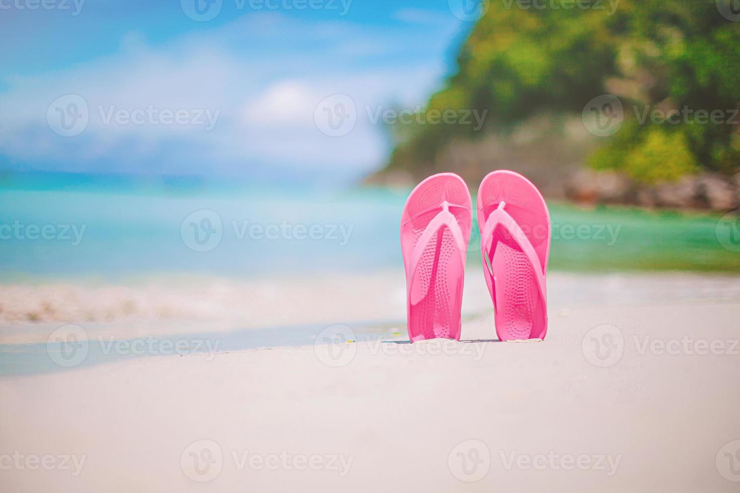 Colorful flipflop pair on the sea beach photo