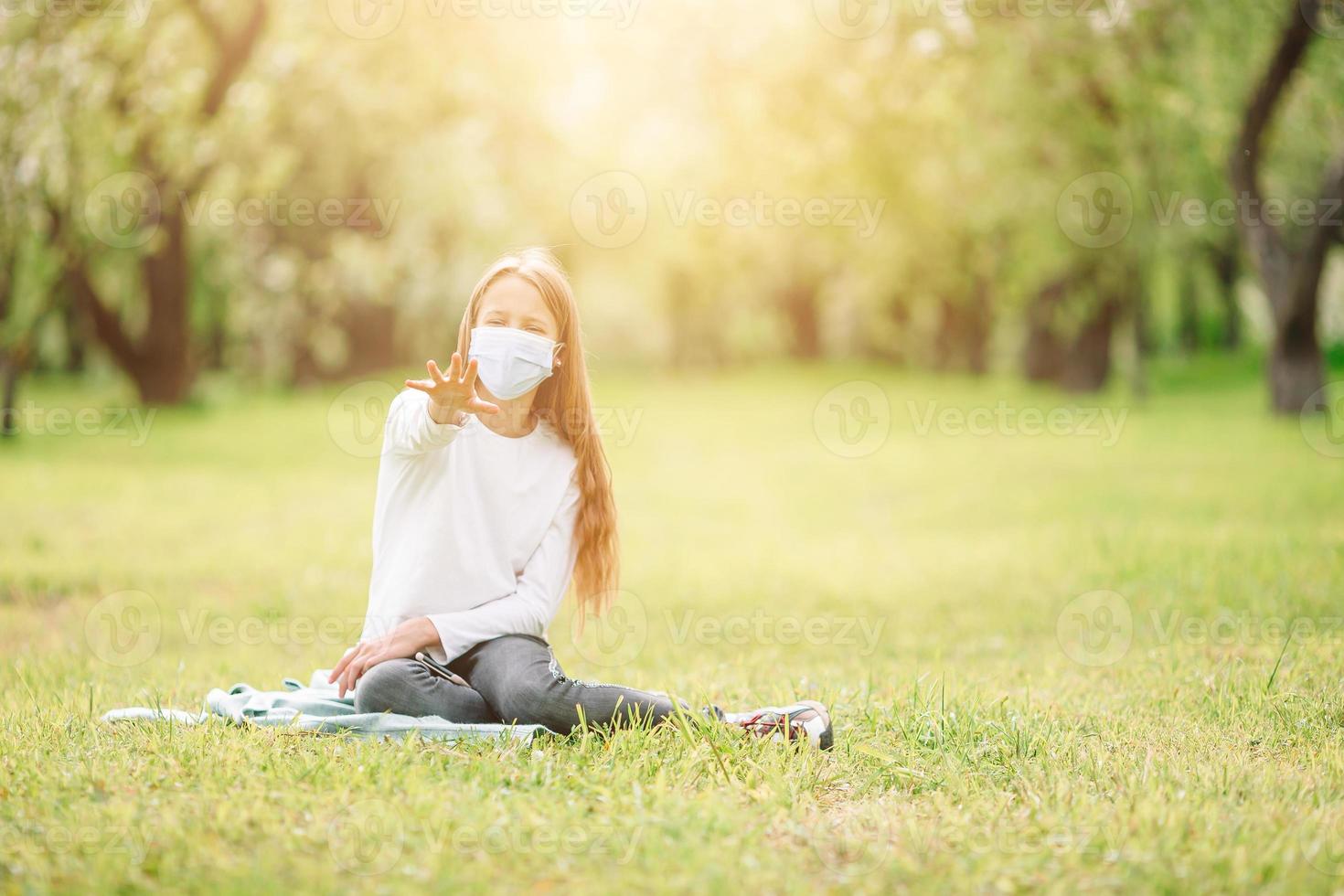 Little girl with dog wearing protective medical mask for prevent virus outdoors in the park photo