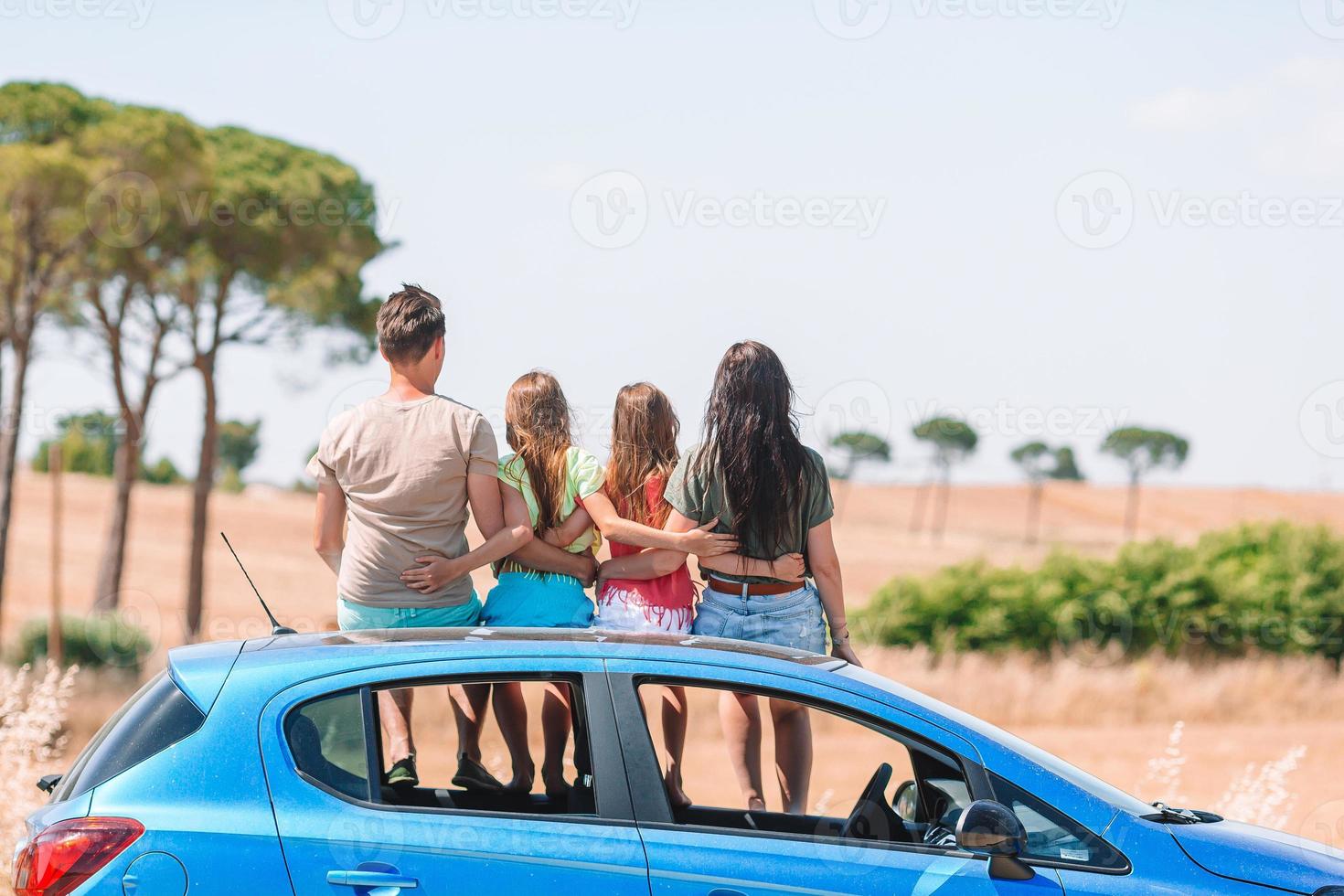 padres y dos niños pequeños en vacaciones de verano en coche foto