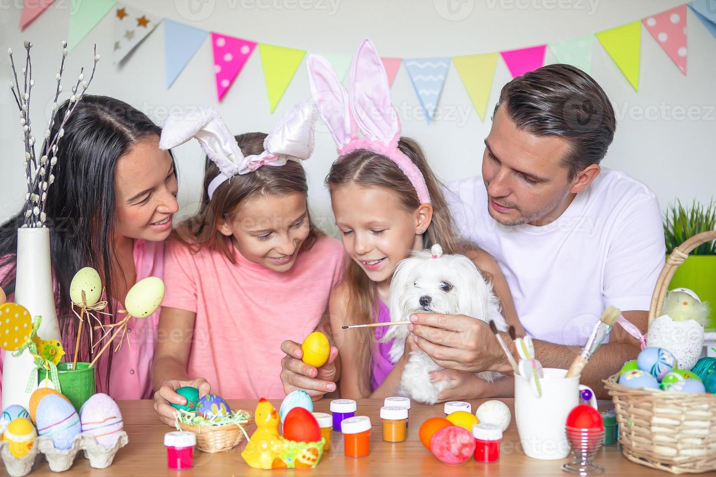 madre y su pequeña hija pintando huevos. familia feliz preparándose para pascua. foto