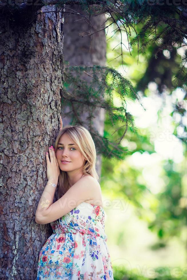 Pregnant woman in outdoor park, warm weather photo