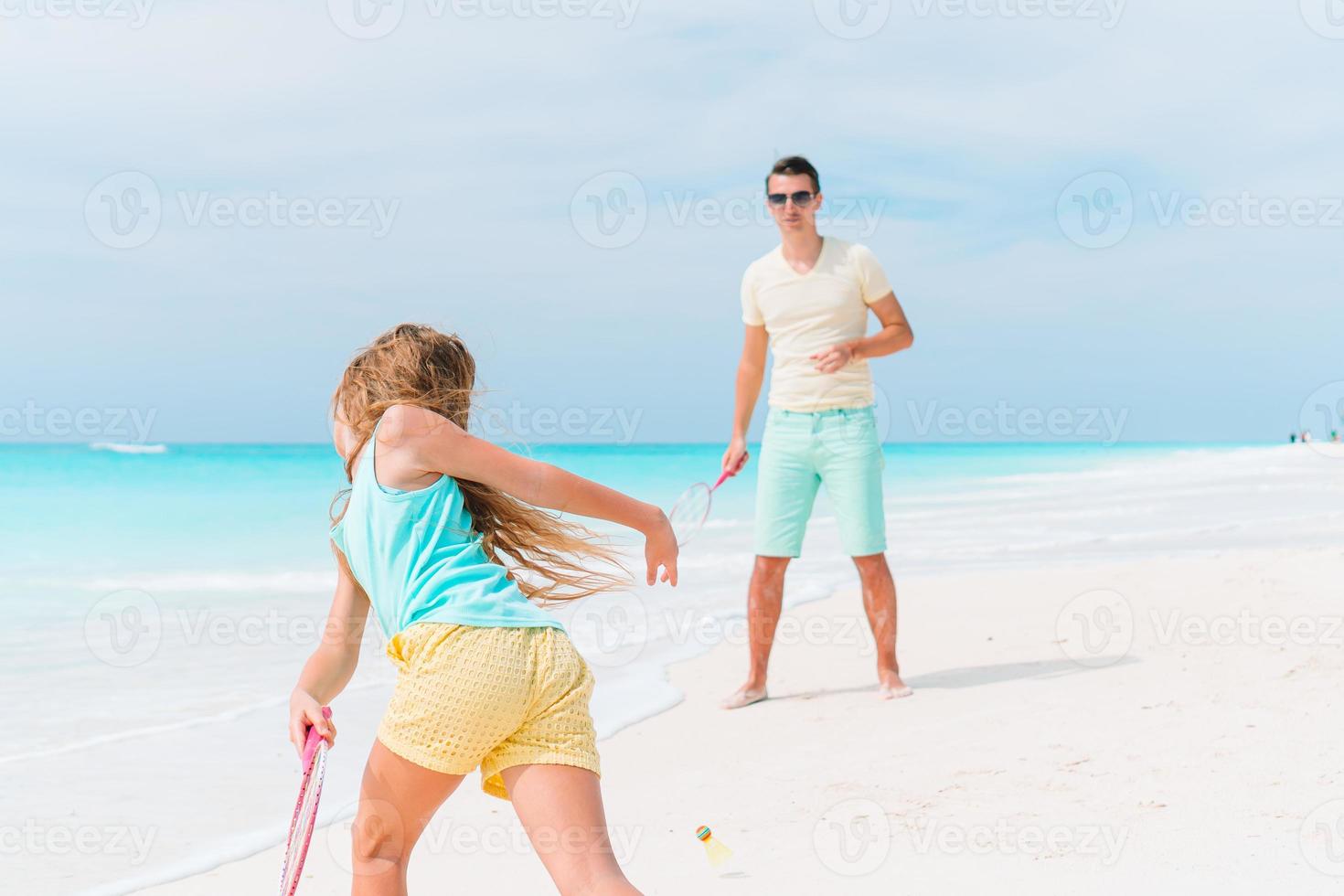 Little girl and happy dad having fun during beach vacation photo